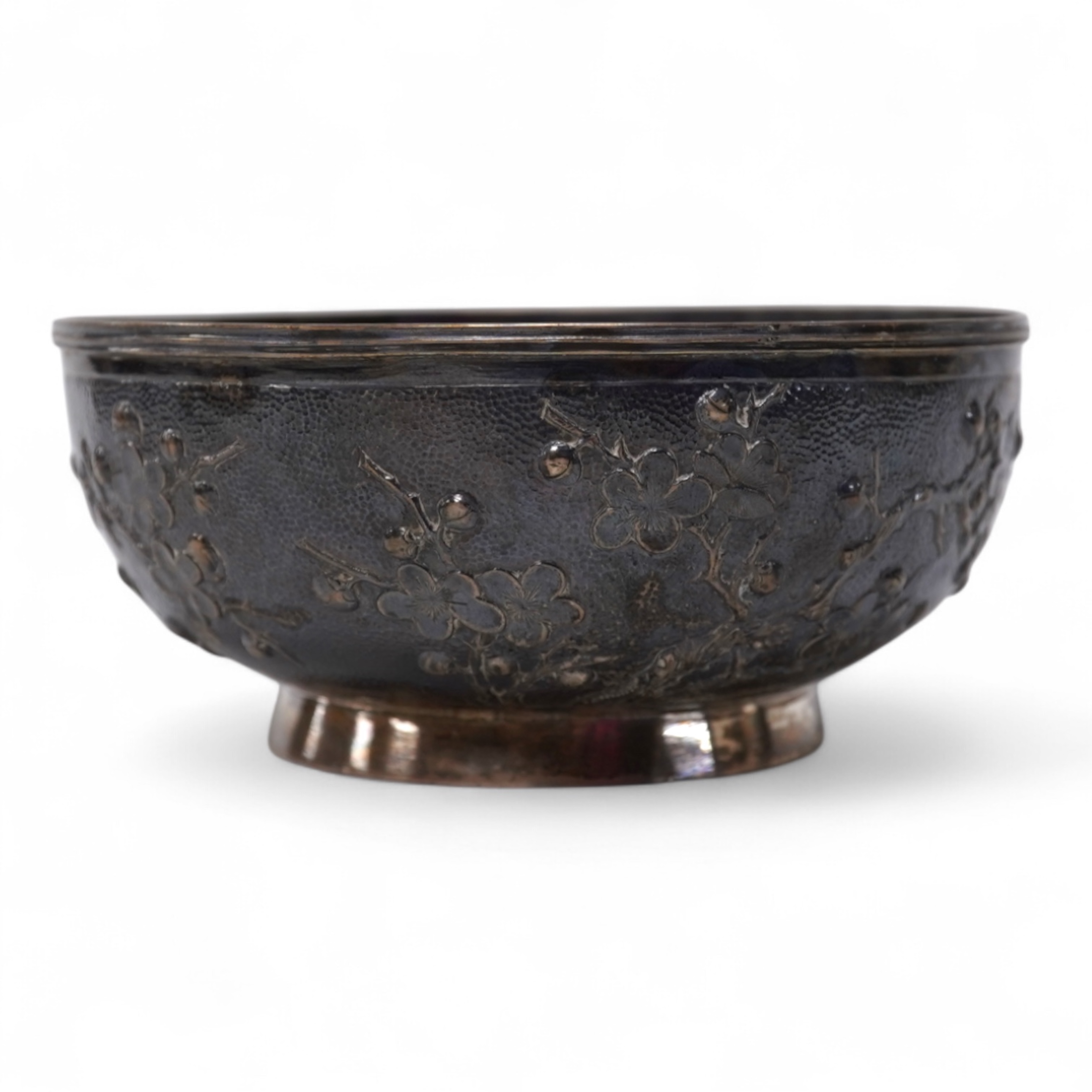 A late 19th/early 20th century Chinese Export white metal bowl, by Wang Hing, Hong Kong, embossed with blossoming prunus branches, diameter 10.6cm, 113 grams.